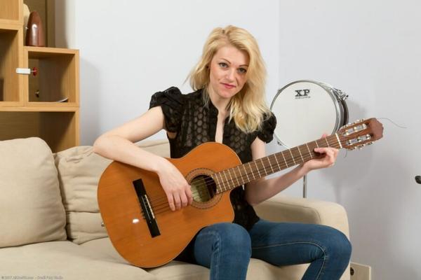 Die reife, blonde Sasha legt ihre Gitarre ab und zieht sich aus.