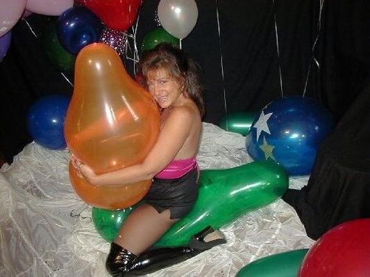 Mujer voluptuosa haciendo estallar globos