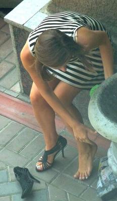 Candid model changing shoes for shooting outdoor